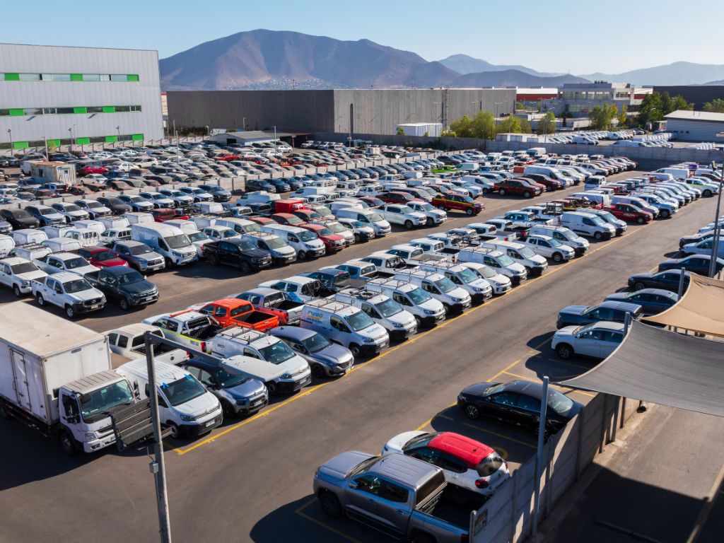 Vista aérea de un patio con múltiples vehículos para empresas estacionados en fila